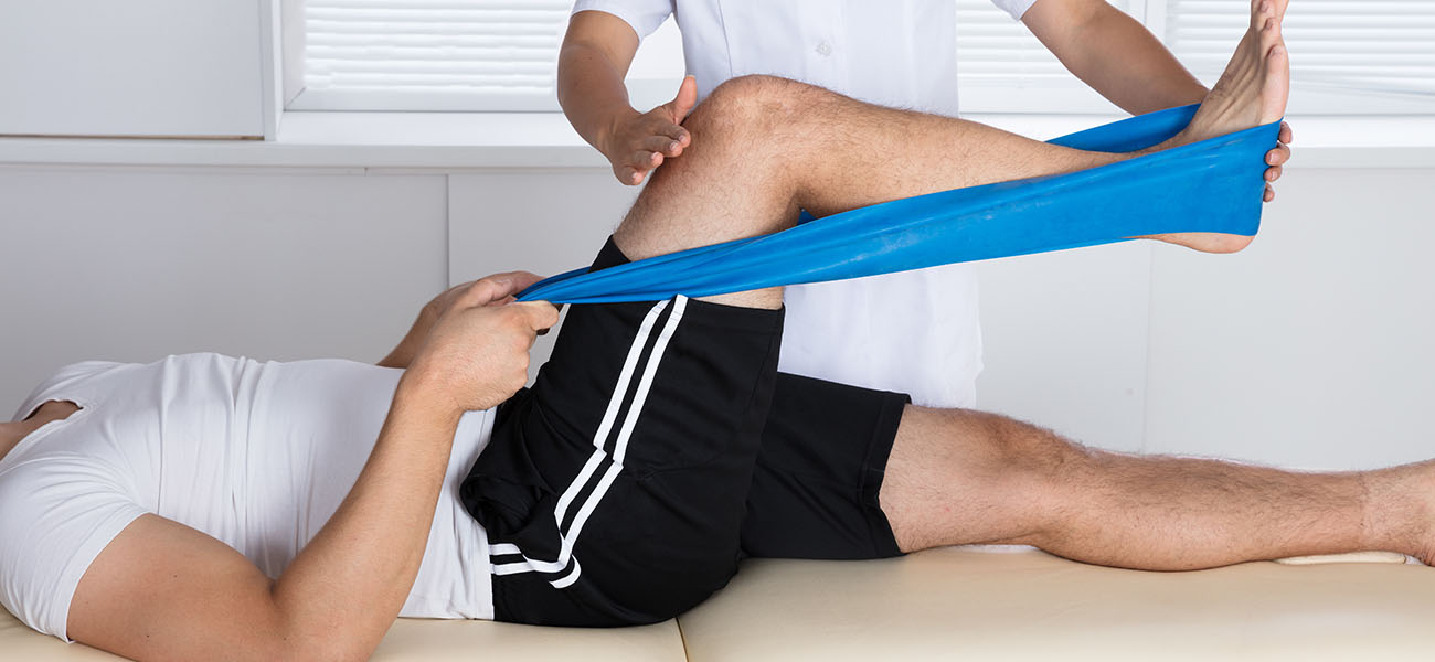 leg strengthening exercise with a blue elastic band