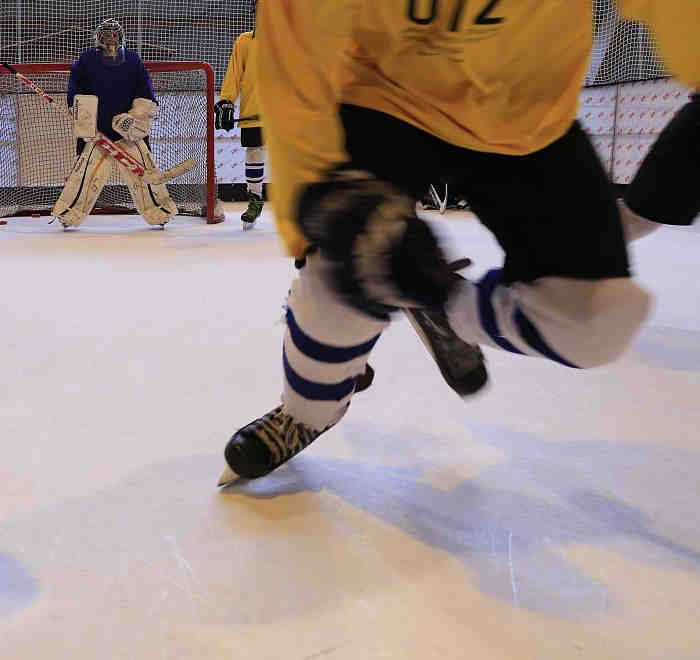 close up of hockey player skating fast at the camera